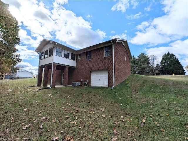 back of house with central AC unit, a sunroom, a garage, and a lawn