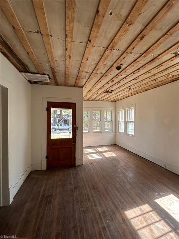 entrance foyer with dark hardwood / wood-style flooring, wood ceiling, vaulted ceiling, and a wealth of natural light