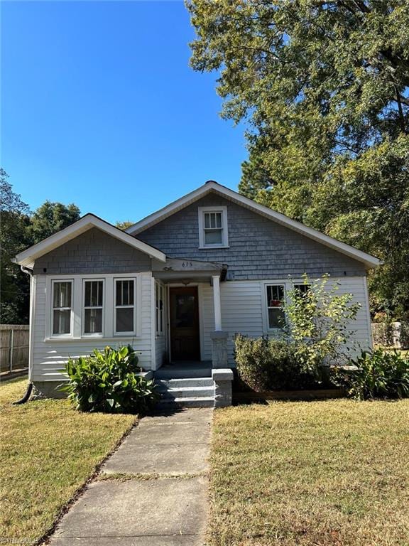 bungalow-style home with a front lawn