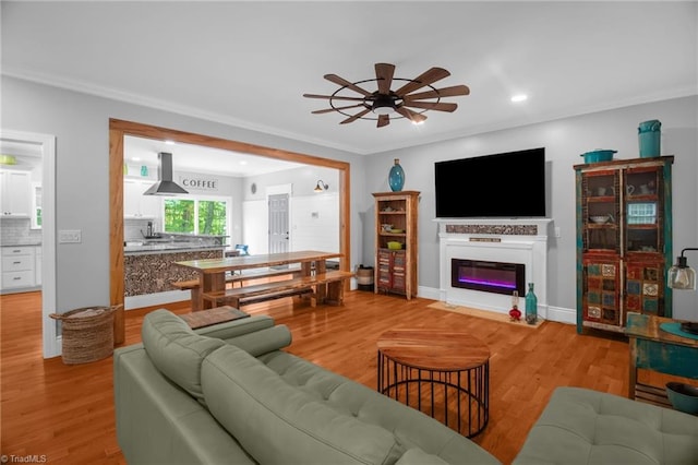 3080 Shiloh Church Rd, Winston-Salem, NC 27105 - living area featuring ceiling fan, light wood-style flooring, a glass covered fireplace, recessed lighting, and crown molding