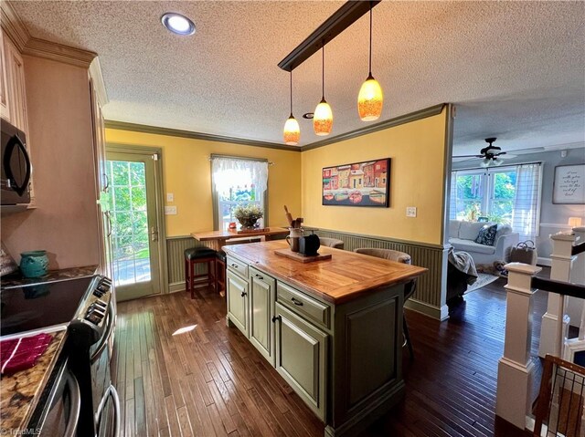 kitchen with decorative light fixtures, dark hardwood / wood-style flooring, stainless steel range with electric stovetop, ceiling fan, and wooden counters