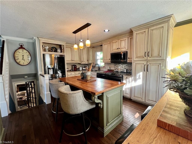 kitchen featuring ornamental molding, wooden counters, dark wood-type flooring, appliances with stainless steel finishes, and pendant lighting