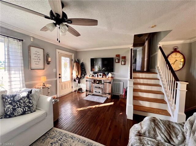 living room featuring a textured ceiling, ceiling fan, dark hardwood / wood-style floors, and crown molding