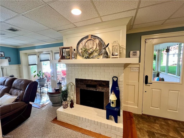 living room featuring a fireplace and a drop ceiling