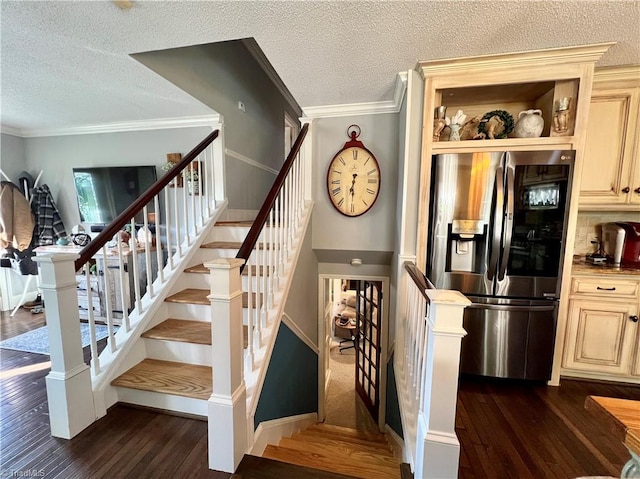 stairs featuring crown molding, a textured ceiling, and dark wood-type flooring