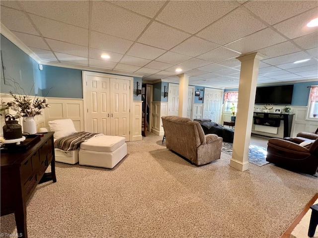 carpeted living room featuring a paneled ceiling and decorative columns