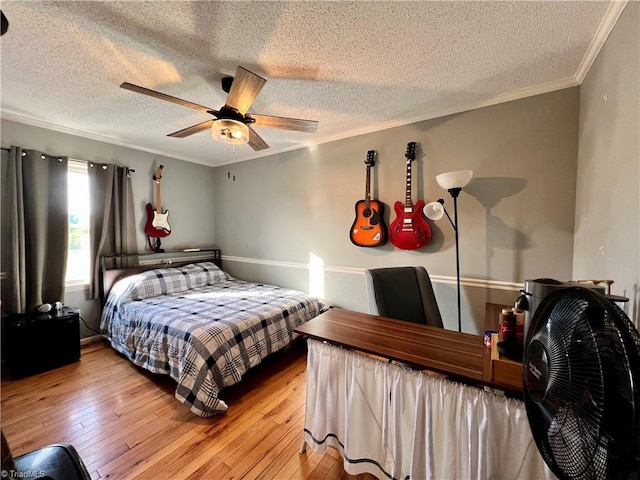 bedroom with ceiling fan, light hardwood / wood-style flooring, and a textured ceiling