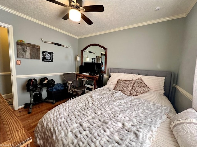 bedroom featuring wood-type flooring, ornamental molding, ceiling fan, and a textured ceiling