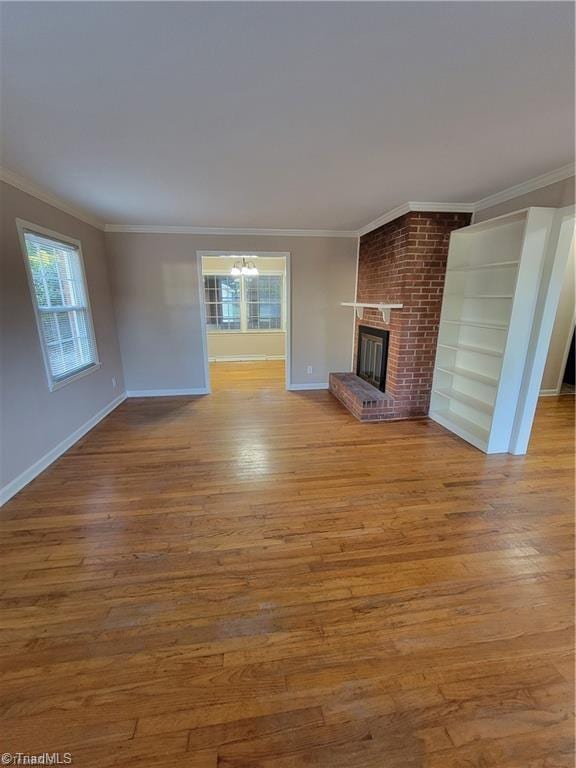 unfurnished living room with crown molding, a fireplace, and wood finished floors