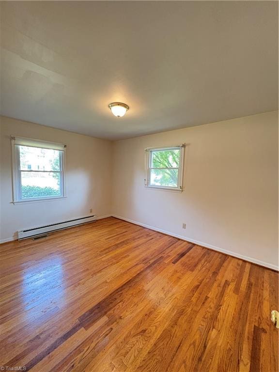 2504 Denise Dr, Greensboro, NC 27407 - unfurnished room with a baseboard radiator and light wood-style flooring
