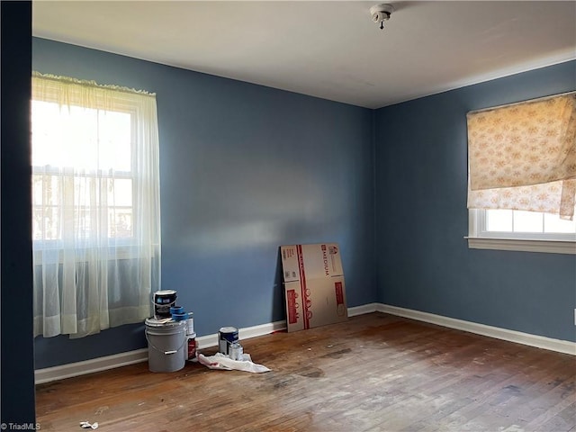 unfurnished room with hardwood / wood-style flooring and a healthy amount of sunlight