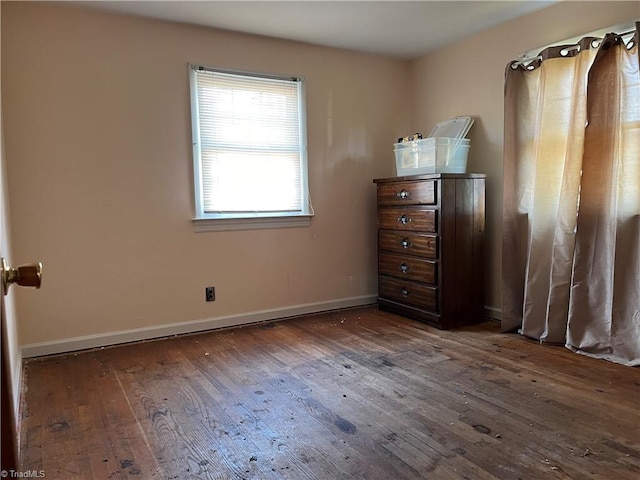 unfurnished bedroom with dark wood-type flooring