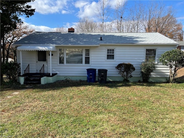 back of property featuring a lawn