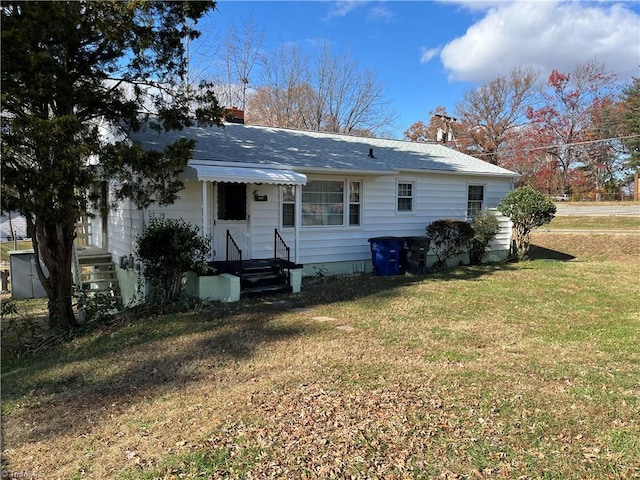 rear view of house featuring a lawn