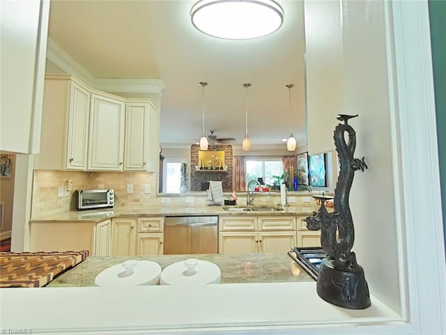 kitchen with backsplash, hanging light fixtures, sink, stainless steel dishwasher, and cream cabinetry