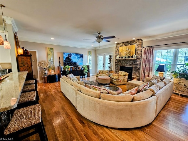 living room with ceiling fan, dark hardwood / wood-style flooring, a healthy amount of sunlight, and ornamental molding