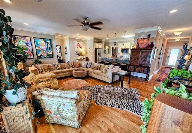 living room featuring ceiling fan, light wood-type flooring, and ornamental molding