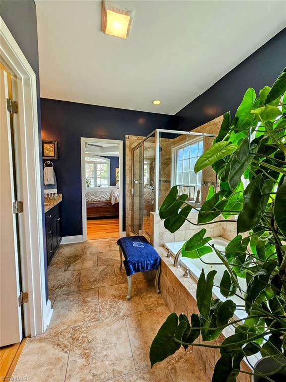 interior space with vanity and separate shower and tub