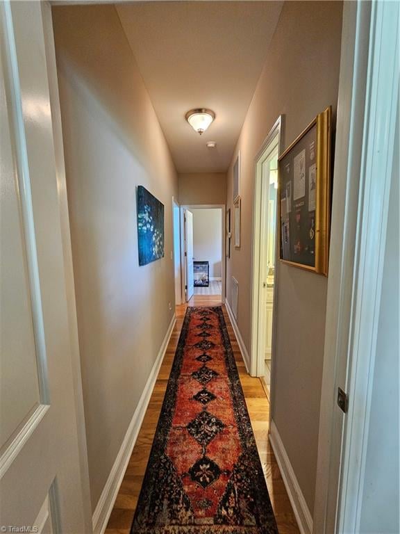 hallway with hardwood / wood-style floors