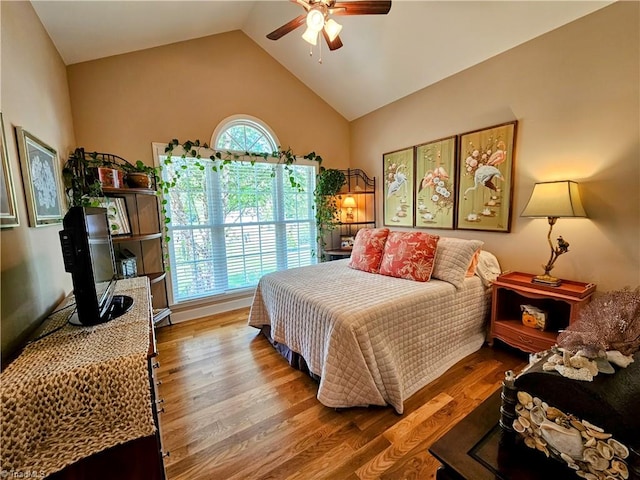 bedroom featuring hardwood / wood-style flooring, vaulted ceiling, multiple windows, and ceiling fan