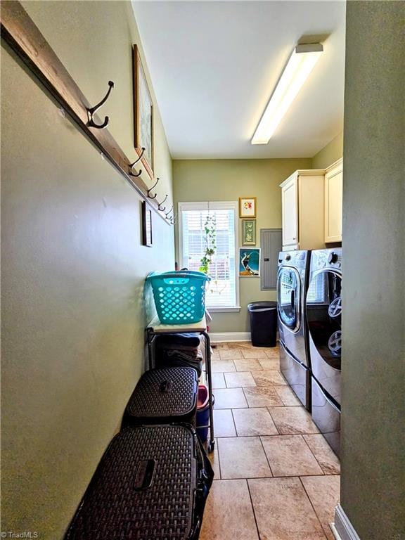 laundry area featuring separate washer and dryer, light tile patterned floors, and cabinets