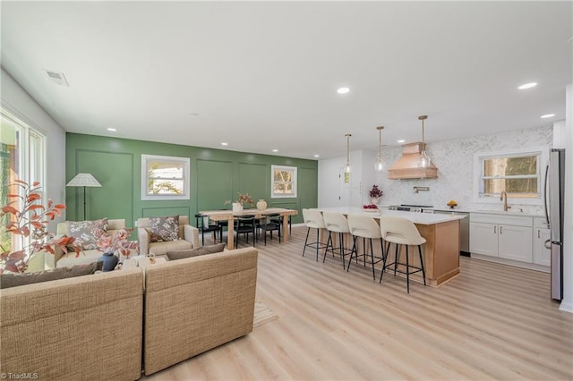 living room featuring sink and light hardwood / wood-style flooring