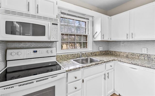 kitchen with sink, white cabinets, white appliances, and decorative backsplash