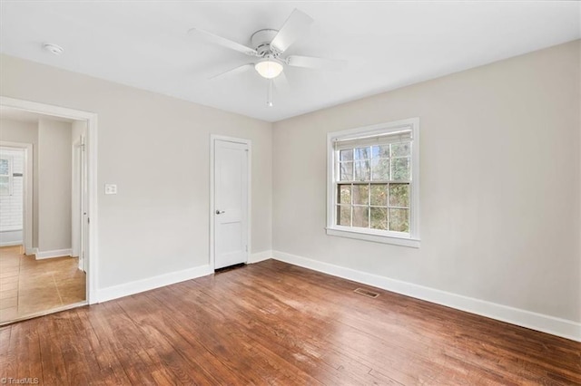 spare room with hardwood / wood-style flooring and ceiling fan