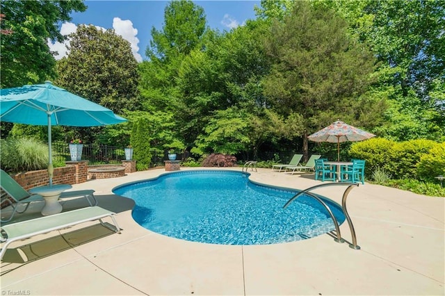 8116 Glengarriff Rd, Clemmons, NC 27012 - swimming pool featuring a patio area, a hot tub, and view of wooded area