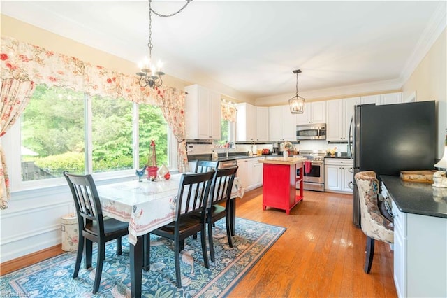 8116 Glengarriff Rd, Clemmons, NC 27012 - dining area with light wood-style floors, ornamental molding, and a chandelier