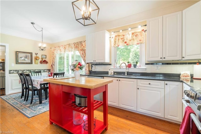8116 Glengarriff Rd, Clemmons, NC 27012 - kitchen with a chandelier, a sink, crown molding, butcher block countertops, and plenty of natural light