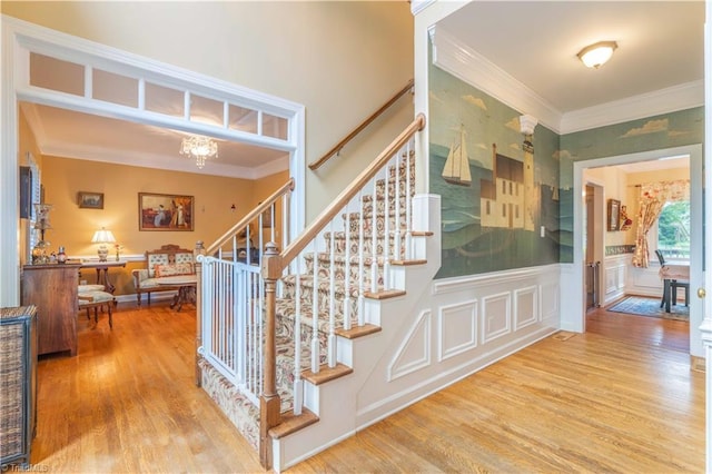 8116 Glengarriff Rd, Clemmons, NC 27012 - stairway featuring crown molding, wood finished floors, and a chandelier