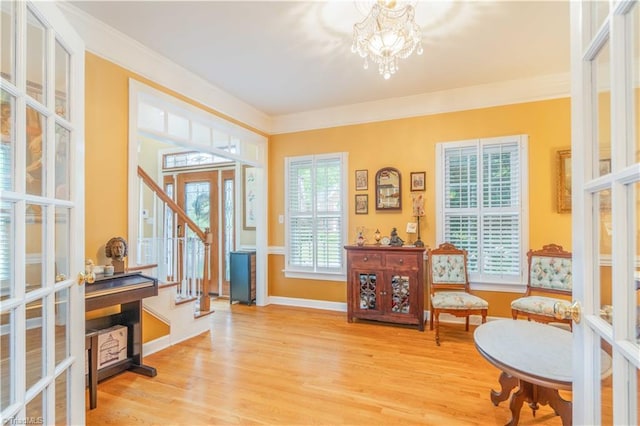 8116 Glengarriff Rd, Clemmons, NC 27012 - entrance foyer featuring french doors, light wood finished floors, a chandelier, ornamental molding, and baseboards