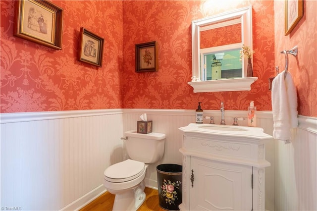 8116 Glengarriff Rd, Clemmons, NC 27012 - bathroom featuring wood finished floors, toilet, vanity, and wainscoting