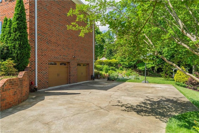 8116 Glengarriff Rd, Clemmons, NC 27012 - view of side of home featuring brick siding, concrete driveway, and an attached garage