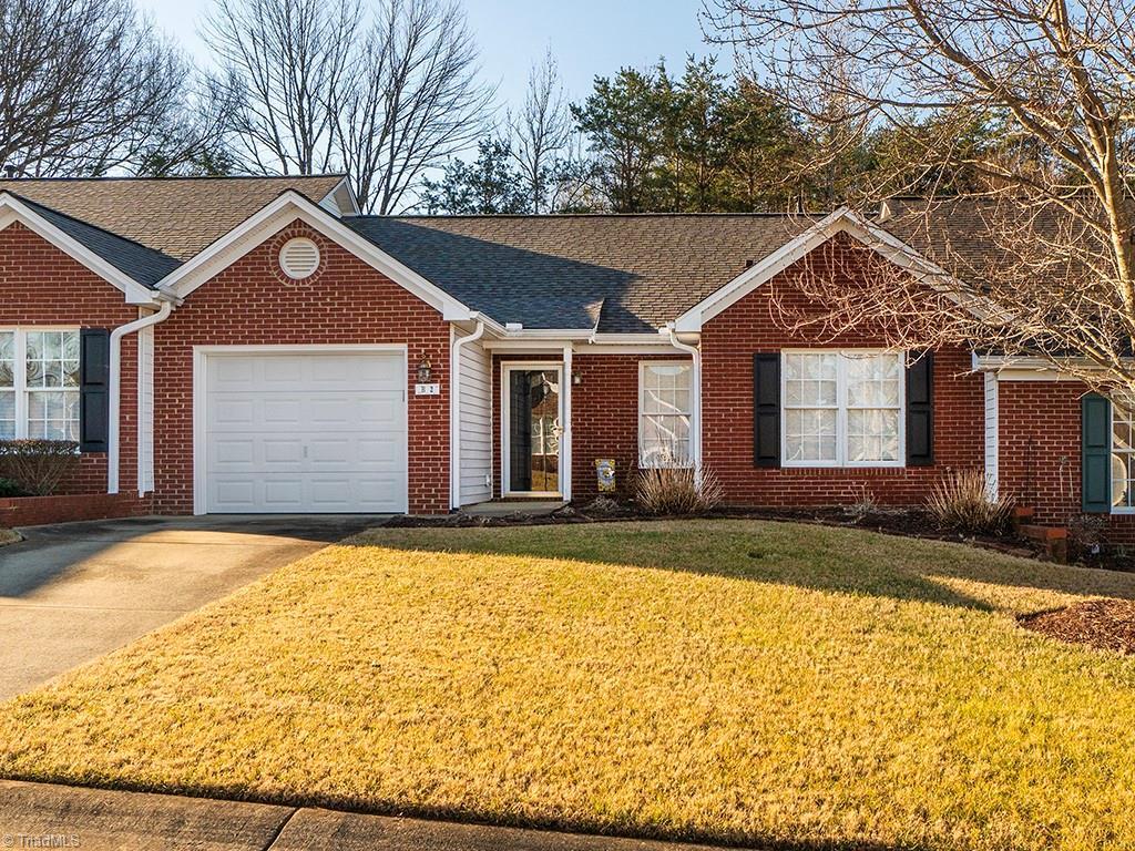 single story home with a garage and a front lawn