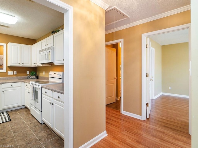 kitchen featuring white cabinetry, a textured ceiling, ornamental molding, dark hardwood / wood-style floors, and white appliances