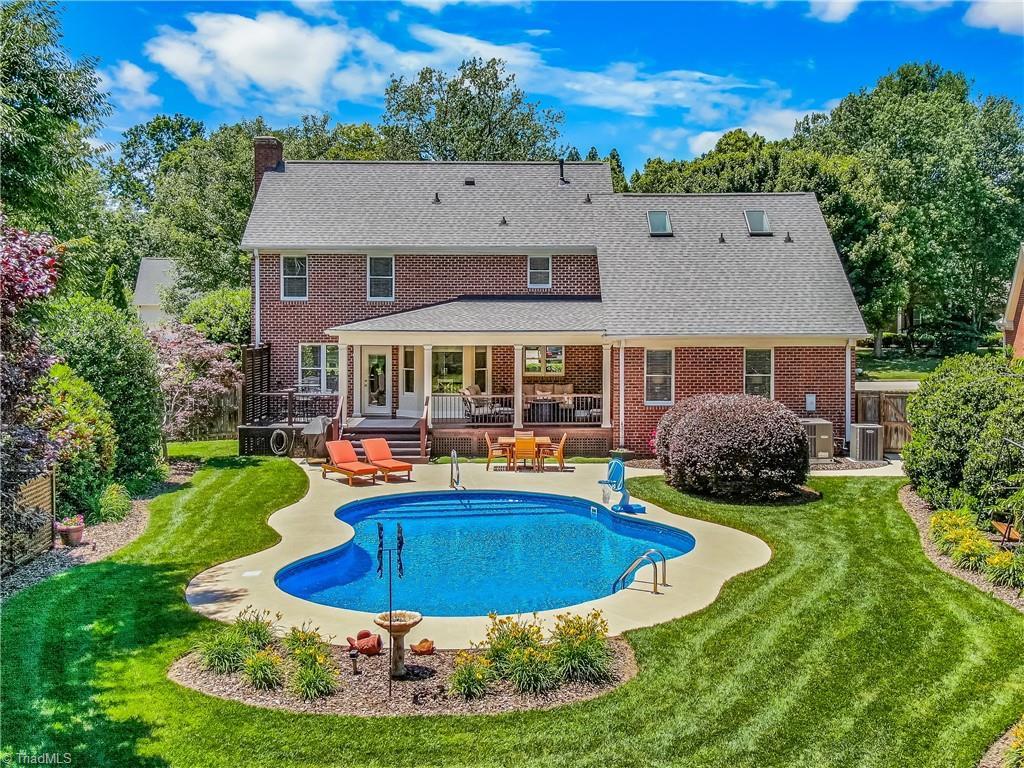 3928 Brandywine St, High Point, NC 27265 - back of house with a patio, a chimney, an outdoor pool, and brick siding