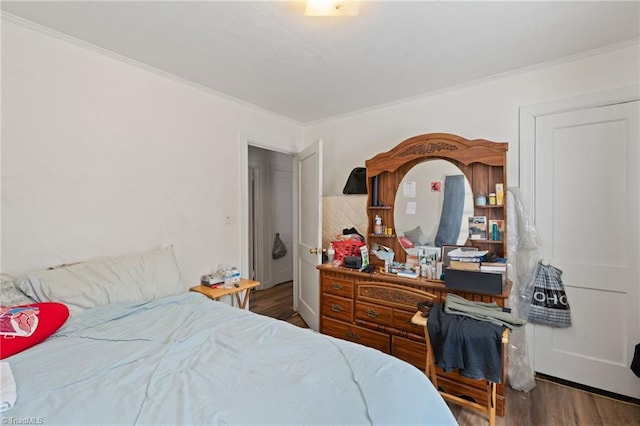 bedroom with dark hardwood / wood-style flooring and ornamental molding