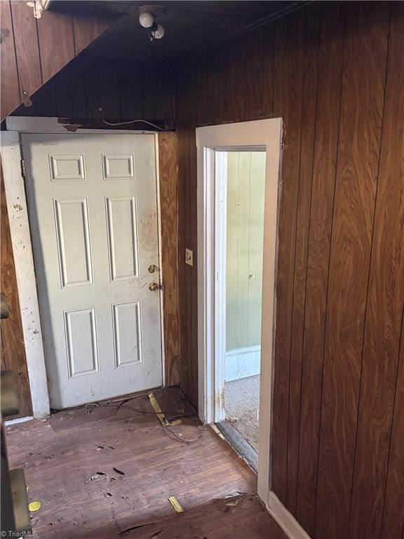 interior space with hardwood / wood-style flooring and wood walls