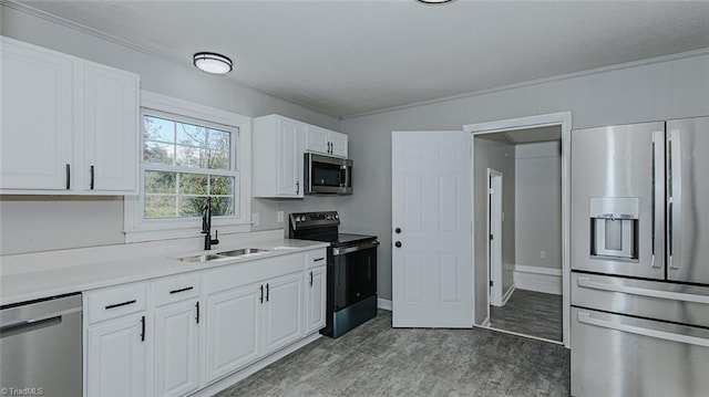 kitchen featuring white cabinetry, crown molding, stainless steel appliances, and sink