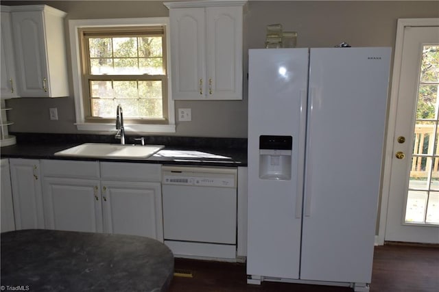 kitchen with white appliances, white cabinetry, a wealth of natural light, and sink