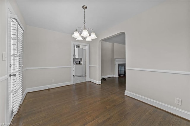 1810 Elm St N, Greensboro, NC 27408 - unfurnished dining area featuring wood finished floors, a chandelier, arched walkways, and a fireplace