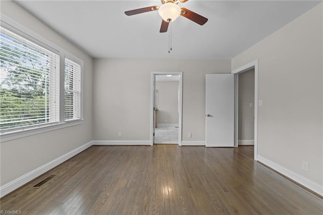 1810 Elm St N, Greensboro, NC 27408 - unfurnished bedroom featuring wood finished floors, a ceiling fan, and connected bathroom