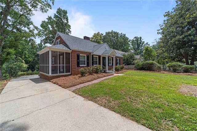 1810 Elm St N, Greensboro, NC 27408 - ranch-style house featuring a sunroom, a front yard, brick siding, a chimney, and driveway