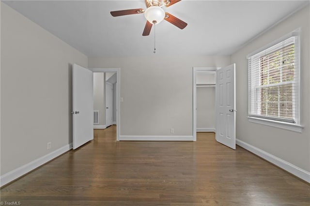 1810 Elm St N, Greensboro, NC 27408 - unfurnished bedroom featuring wood finished floors, a walk in closet, a ceiling fan, and a closet