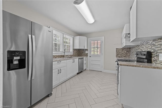 1810 Elm St N, Greensboro, NC 27408 - kitchen with appliances with stainless steel finishes, backsplash, white cabinetry, and light stone countertops
