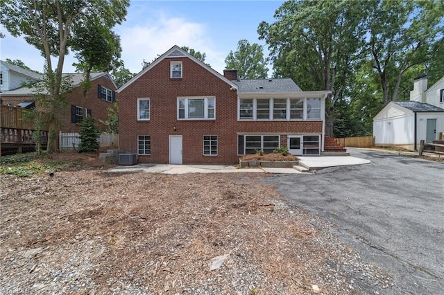 1810 Elm St N, Greensboro, NC 27408 - rear view of property with brick siding, a patio area, a sunroom, and a chimney