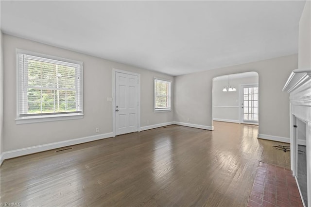 1810 Elm St N, Greensboro, NC 27408 - unfurnished living room with a fireplace with flush hearth, a chandelier, and dark wood finished floors