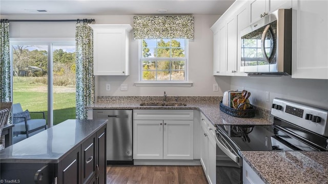 kitchen featuring sink, white cabinetry, stainless steel appliances, and plenty of natural light